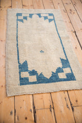 Distressed Oushak rug runner's textured pile, blue serrated border, and intact selvage.