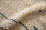 Distressed antique ivory Oushak rug pile, showing wear and cobalt blue motif.