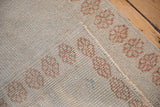 The hand-knotted foundation of a distressed Turkish Oushak rug in ivory and pale copper.