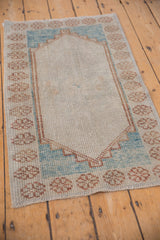 Distressed Oushak rug's main field with antique ivory texture, showing even pile wear.