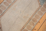 Distressed Oushak rug pile close-up, showing even wear, ivory, pale brown, and blue floral details.