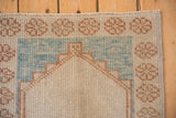 Distressed Oushak rug corner with floral pale coffee border and powder blue field outline.