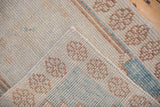 Distressed Oushak rug pile texture with even wear, featuring muted ivory, pale blue, and brown.