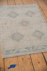 Distressed Oushak rug pile shows ivory and powder blue, with even wear and faint foundation.