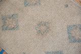 Distressed Oushak pile close-up, ivory and powder blue with wear to knot heads.