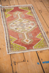 Distressed terra cotta Oushak rug mat with lime green and ivory geometric design.