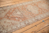 Distressed vintage Oushak runner's machine-bound side, showing faded copper and beige patterns.