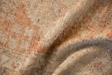 Textured close-up of distressed Oushak rug runner with worn beige and pale copper.