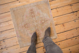 Faded central medallion and distressed texture on a vintage Oushak square rug.