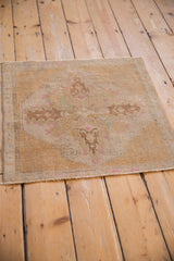 Distressed Oushak rug's faded pile, white knots, and machine bound lower edge.