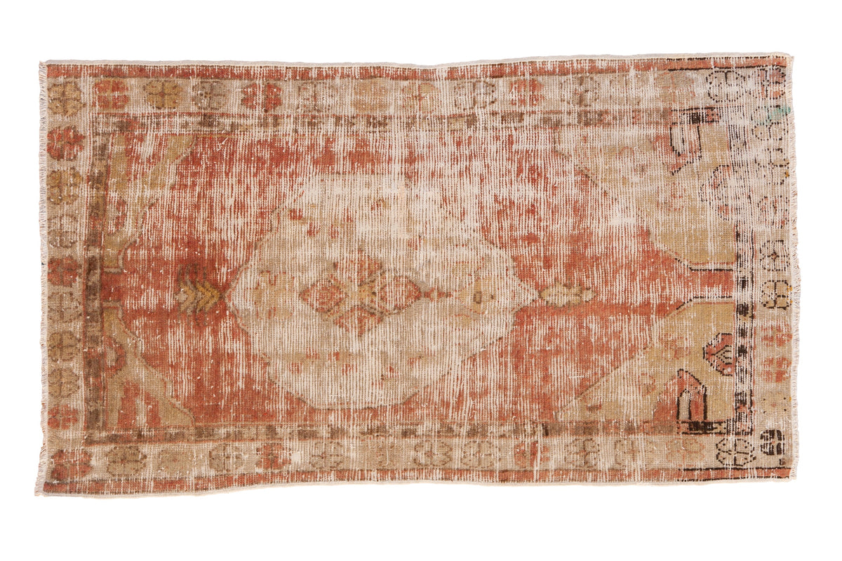 Vintage distressed Oushak rug with a faded central medallion in shades of dusty blush, ivory, and wheat.