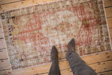 A view from above showing the scale and decorative worn texture of a vintage Oushak rug.