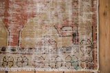 Corner detail of a distressed vintage Oushak showing worn pile and visible foundation weave.