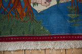 Close-up of the hand-knotted fringe and cherry red border on a vintage pictorial Persian rug.
