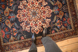 Overhead perspective on the dense, hand-knotted pile and roundel medallion of an antique Kurdish Bijar rug.