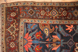 Detail of the main border on an antique Kurdish Bijar rug, with boteh and Samovar motifs in wine red and blue.