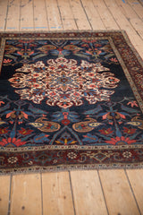 Angled view of an antique Kurdish Bijar rug, highlighting its oversized roundel medallion.