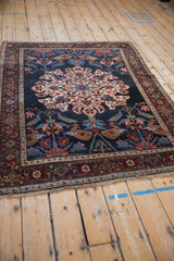 Angled perspective on an antique Kurdish Bijar rug showing its oversized roundel medallion and rich border.