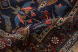A folded view of an antique Kurdish Bijar rug reveals its dense navy pile and Samovar motif border.