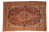 Antique Farahan Sarouk carpet with a scrolling floral medallion, navy field, and beige spandrels with peacock motifs.