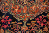 Colorful arabesques and fuchsia floral vines on the navy ground of an antique Farahan Sarouk.