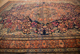 A view across the intricate floral arabesques and medallion of an antique Farahan Sarouk carpet.