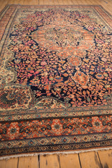 Colorful scrolling arabesques and vines on the low, even pile of an antique Persian Sarouk rug.