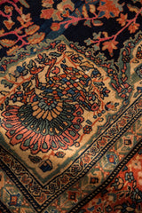 Elaborate peacock and floral motif within the corner spandrel of an antique Farahan Sarouk carpet.