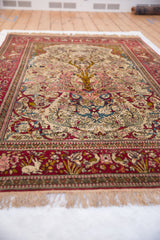 Low angle view across an antique Isfahan rug showing the detailed Tree of Life and pictorial red border with animals.