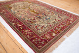 Full perspective of the pictorial Tree of Life antique Isfahan rug with its detailed cochineal red border.
