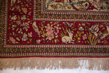 Corner of an antique Isfahan rug with a pictorial border showing a rabbit, bird, and its natural fringe.