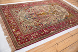 Antique Isfahan rug's full pictorial design featuring a Tree of Life and cochineal red animal border.
