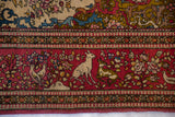 Pictorial border of a collector Isfahan rug with rabbits, deer, and birds on a cochineal red field.