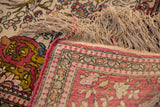 A detailed view of the antique Isfahan's original red side cord selvage and hand-knotted fringe.
