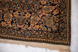 The reciprocating pawn motif border and full pile of an antique Mohtashem Kashan rug corner.