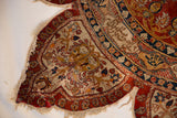 Storied condition of a Collector silk Tabriz rug, showing the tattered edges and finely woven inscription border.