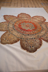 Angled view of a collectible silk Tabriz rug's unique roundel form and elaborate trefoil perimeter.