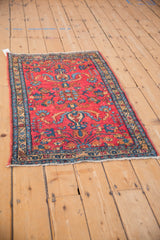 A vintage Persian Lilihan rug with a raspberry floral field and golden-toned border.
