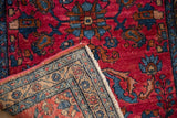 Folded corner of a vintage Lilihan rug showing its golden border and hand-knotted foundation.