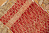 Worn knot heads and heavy abrash visible across the cherry red lattice design.