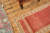 Distressed Turkish Oushak runner showing heavy color abrashes across its red lattice field.