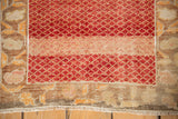 Worn texture showing the knot heads of the floral border and red lattice field.