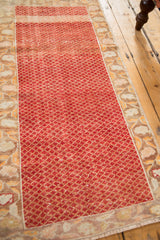 Angled perspective of a distressed Turkish Oushak runner showing its red lattice field and worn texture.