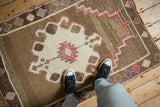 A standing view over the vintage distressed Kars rug, highlighting its low-pile texture and central medallion.