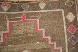 Corner detail of a distressed Kars rug showing the raspberry stepped pattern and worn, low pile.