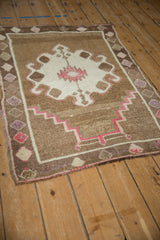Angled view of a vintage Turkish Kars rug showing its geometric prayer design and soft, distressed texture.