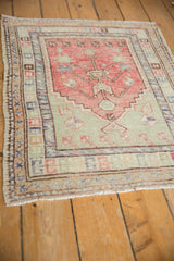 Multiple geometric and floral borders framing the stepped field of a distressed Oushak rug.