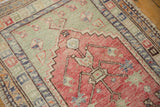 Close view of the distressed Oushak's tree of life motif, showing its low pile and faded colors.