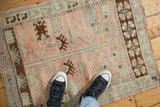 Distressed low-pile texture of a vintage Oushak rug in pale rose, silver, and chocolate brown.