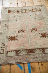 Angled perspective showing the even wear of this distressed vintage Oushak rug.